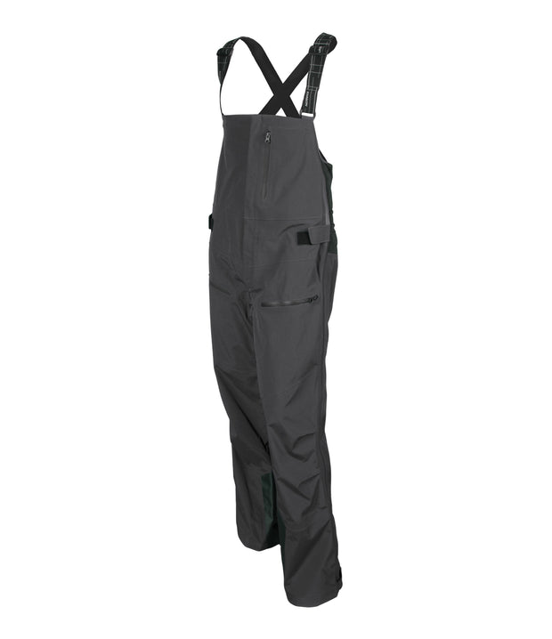 A pair of grey shell bib pants with intergrated suspenders, full-length side zip, a zippered chest pocket, thigh pockets with cover flap and a side adjuster.