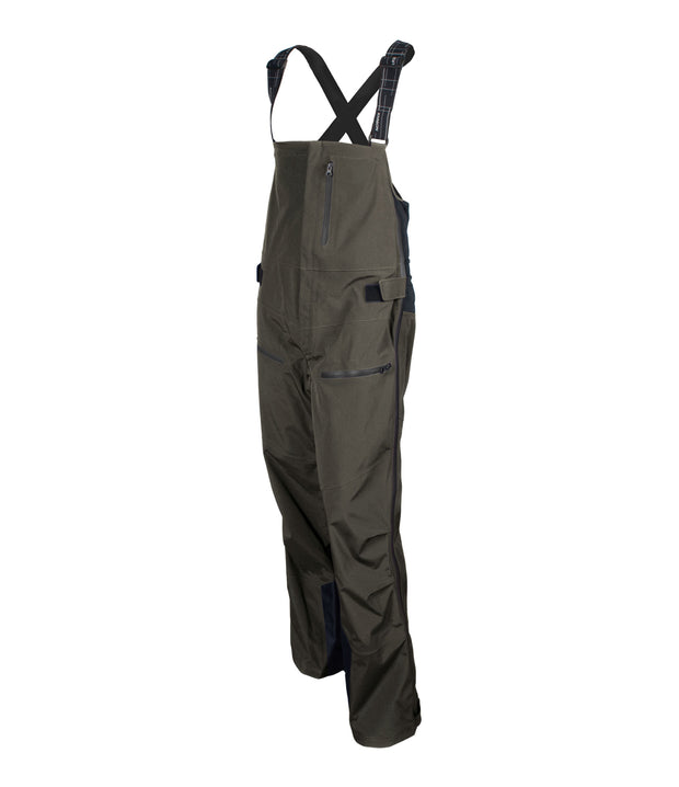 A pair of dark green shell bib pants with intergrated suspenders, full-length side zip, a zippered chest pocket, thigh pockets with cover flap and a side adjuster.