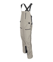 A pair of beige shell bib pants with intergrated suspenders, full-length side zip, a zippered chest pocket, thigh pockets with cover flap and a side adjuster.