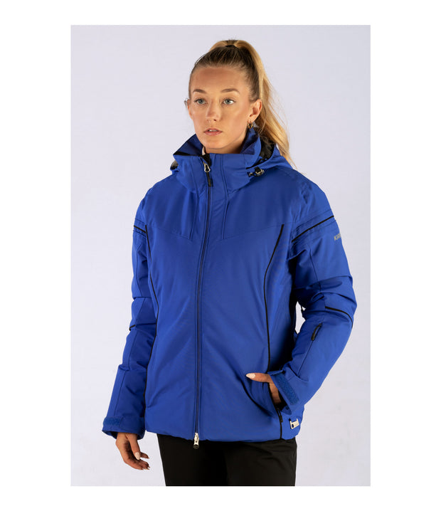 A woman wearing a blue insulated ski jacket with a hood, featuring black trim, a hood, velcro tabs, and a drawcord hem.