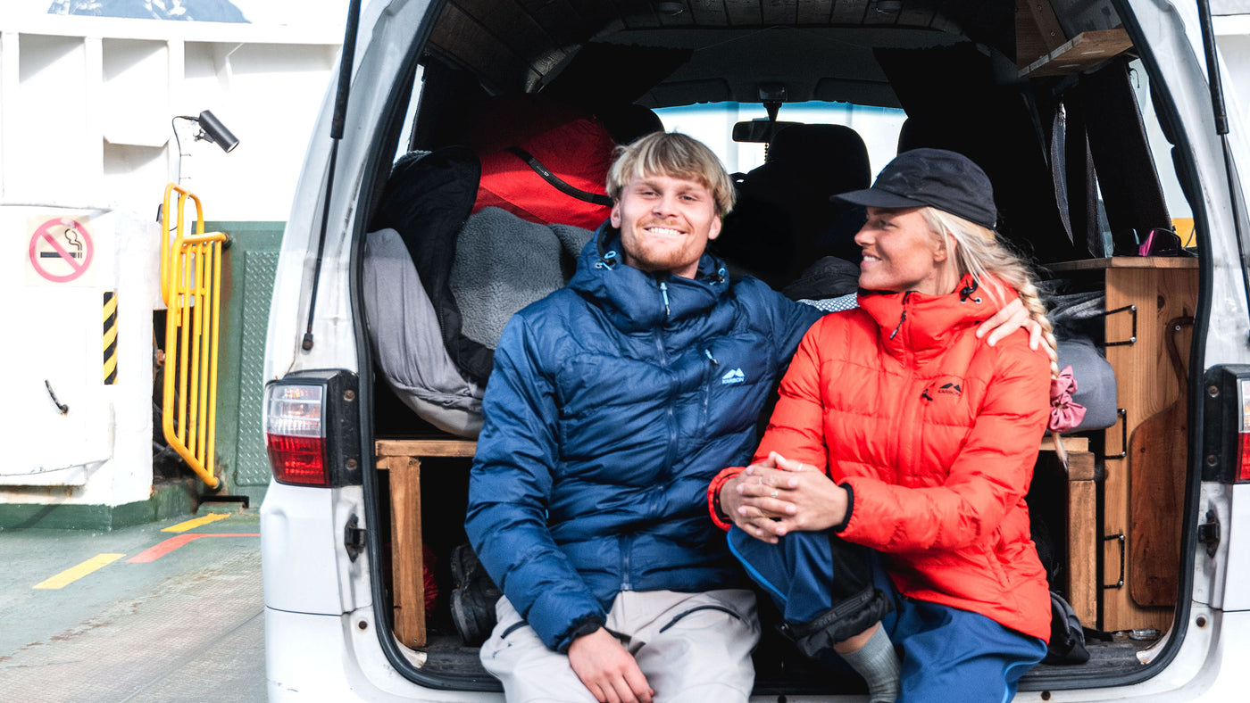 Two people sitting inside a van with a white background